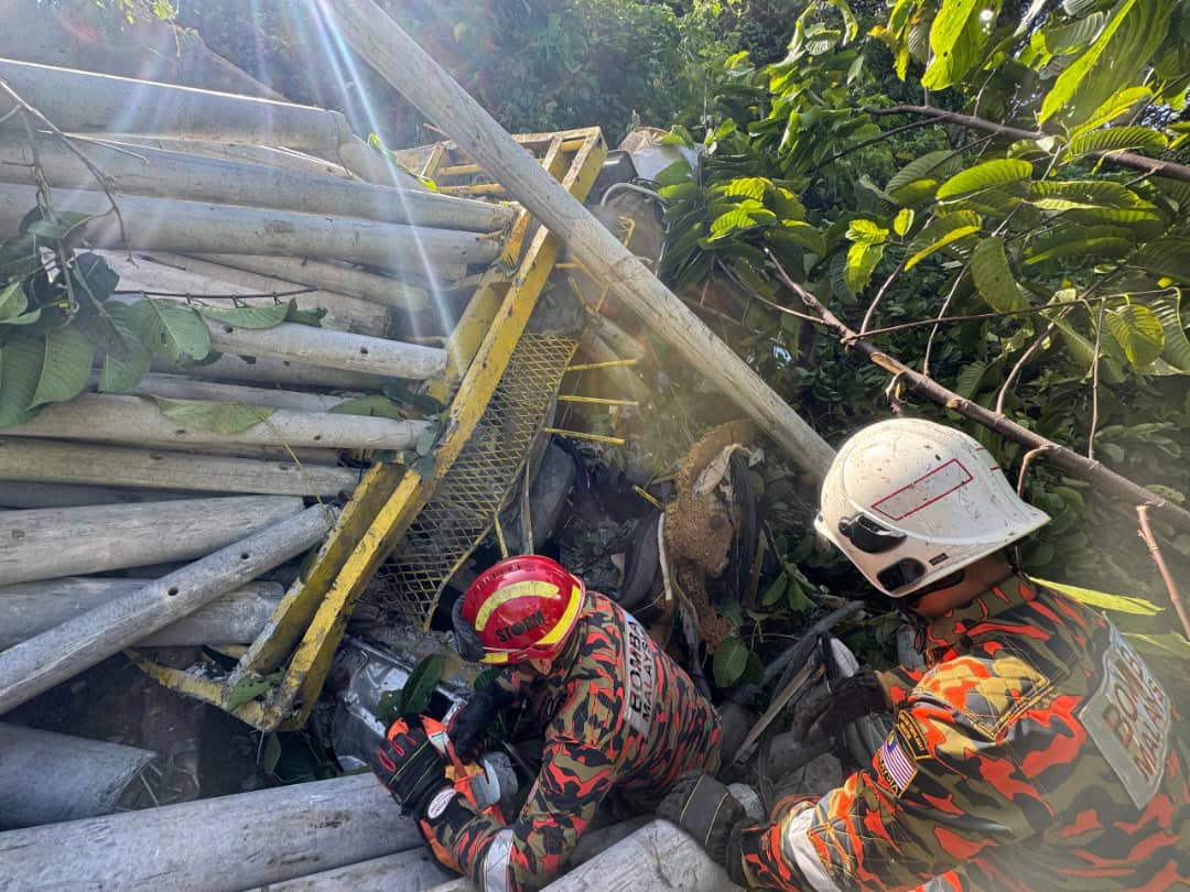 Firefighters work tirelessly to clear the concrete poles from the crash site as part of the 19-hour rescue mission in Kampung Nabutan, Ranau.